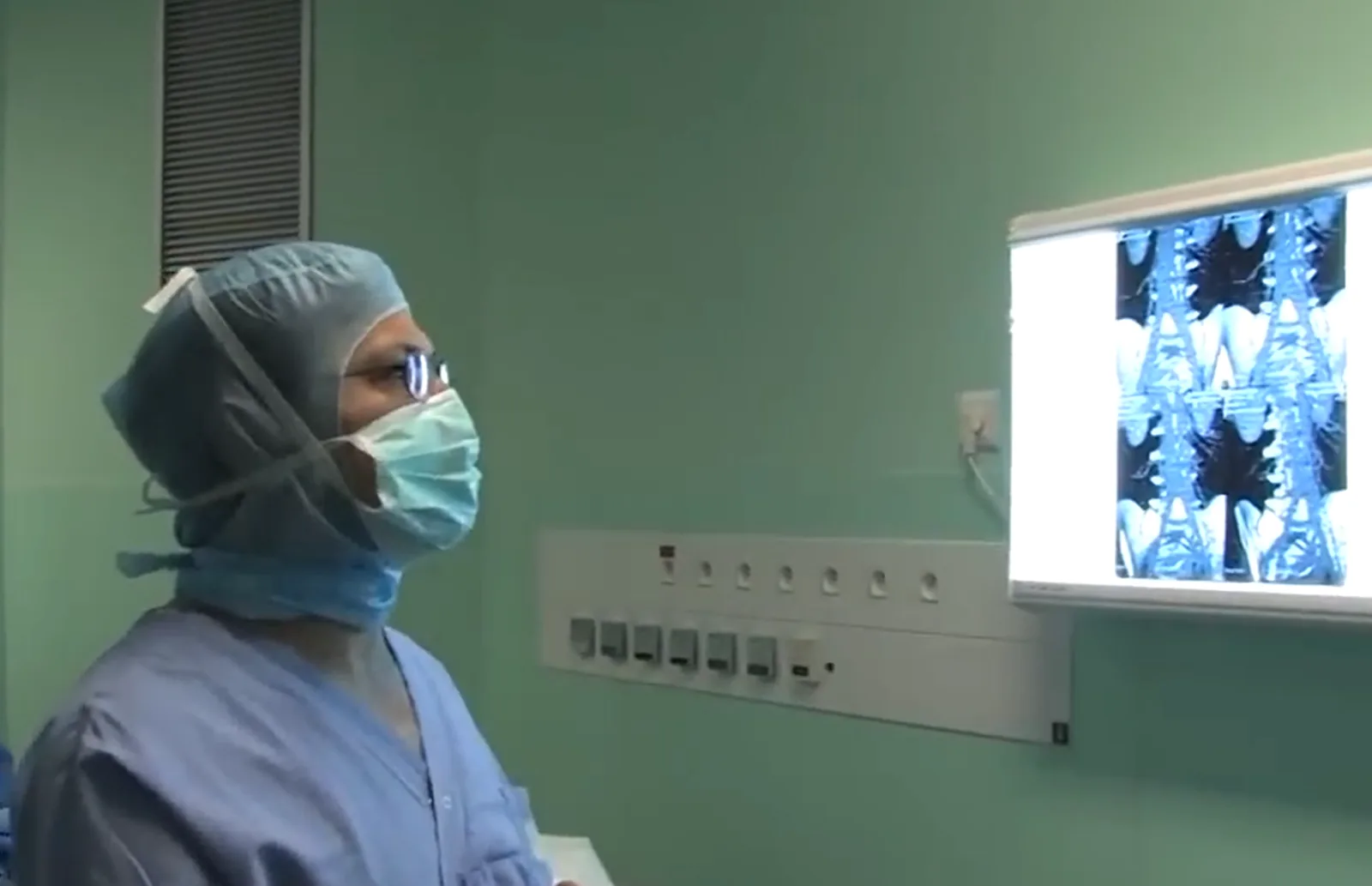 Neurochirurgien en bloc opératoire devant des images médicales